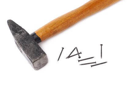 Big hammer with pile of metal nails over white isolated backgroundの写真素材