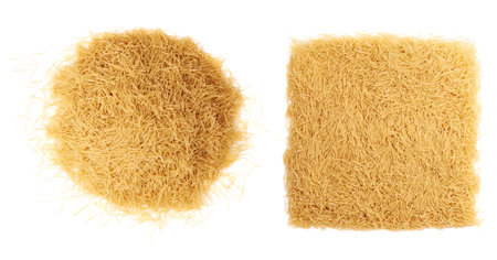 Pile of dry noodles yellow pasta over isolated white backgroundの写真素材