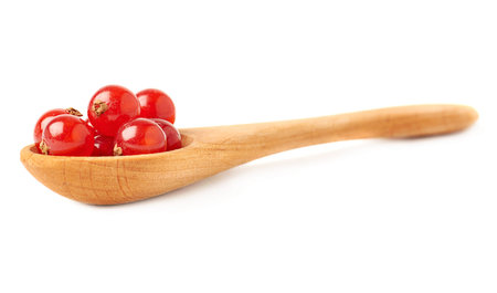 Wooden spoon filled with ripe Red Currant berries isolated over white backgroundの写真素材