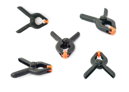 Set of Pair of black clamp with orange plastic jaws, isolated over the white background