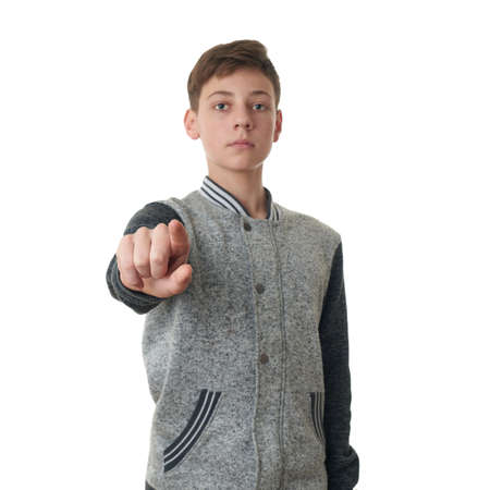 Cute teenager boy in gray sweater pointing forward over white isolated background, half bodyの写真素材