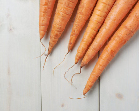 Bunch of raw whole carrots on white wooden surface tableの写真素材