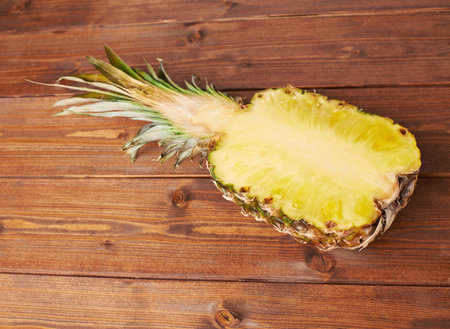 Raw cut pineapple on wooden brown surface table