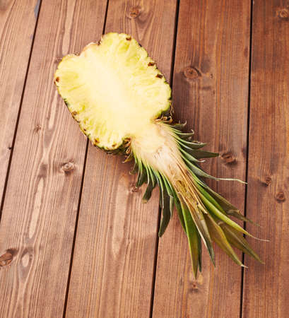 Raw cut pineapple on wooden brown surface tableの写真素材