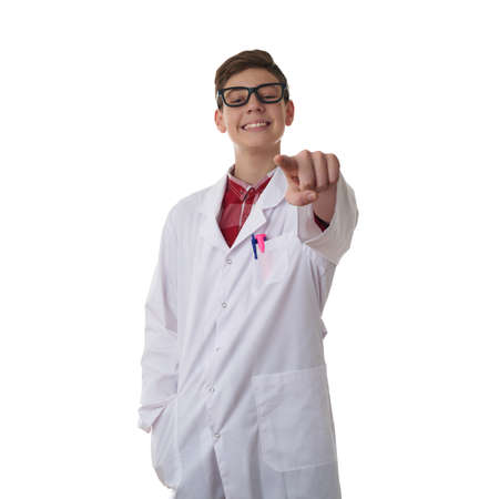 Cute teenager boy wearing white lab medic coat and glasses, pointing forward over white isolated background as science, medicine, healthcare conceptの写真素材