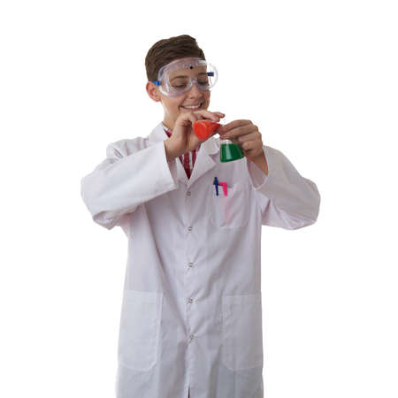 Cute teenager boy wearing white lab medic coat and protecting glasses with flask over white isolated background as science, experiment, healthcare conceptの写真素材