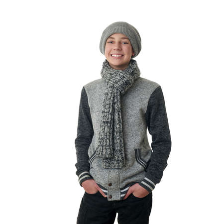 Cute teenager boy in gray sweater, hat and scarf over white isolated background, half bodyの写真素材