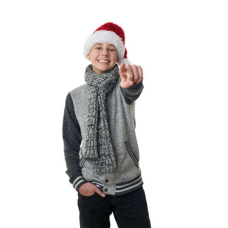 Cute teenager boy in gray sweater and christmas hat pointing forward over white isolated background, half bodyの写真素材