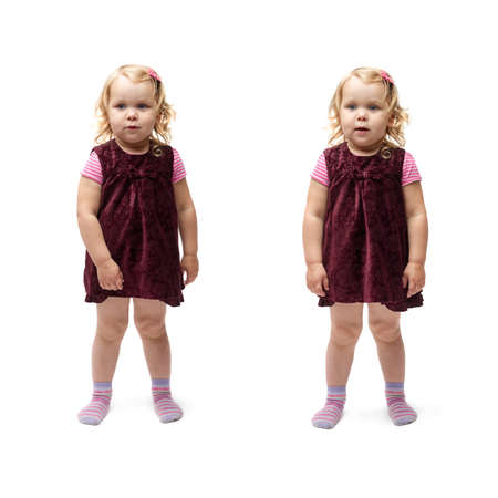 Young little girl with curly hair in purple dress standing over isolated white backgroundの写真素材