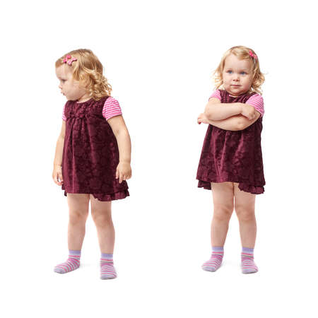Young little girl with curly hair in purple dress standing over isolated white backgroundの写真素材