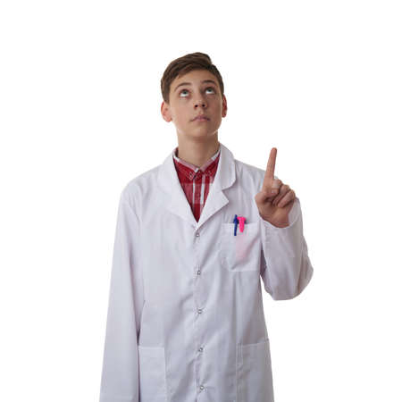 Cute teenager boy wearing white lab medic coat pointing up over white isolated background as science, medicine, healthcare conceptの写真素材