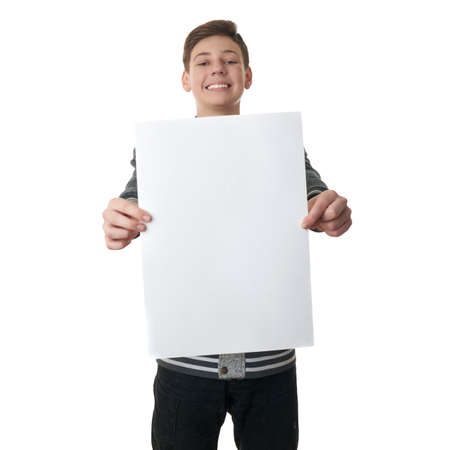 Cute teenager boy in gray sweater holding paper bill board over white isolated background, half bodyの写真素材