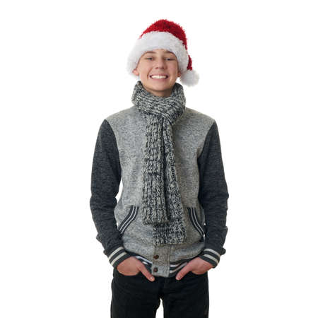 Cute teenager boy in gray sweater and christmas hat over white isolated background, half bodyの写真素材
