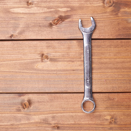 Wrench chrome metal spanner instrument on wooden brown surface
