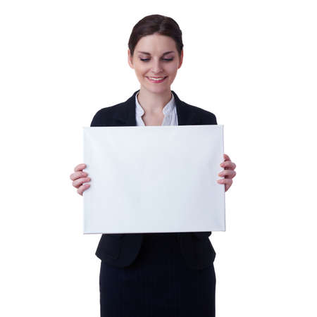 Smiling businesswoman standing over white isolated background with white blank board, business, education, office, advertising conceptの写真素材
