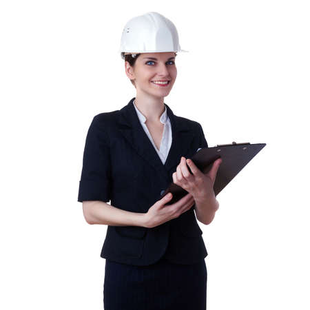 Smiling businesswoman standing over white isolated background in white helmet with clipboard, business, education, construction and architecture conceptの写真素材