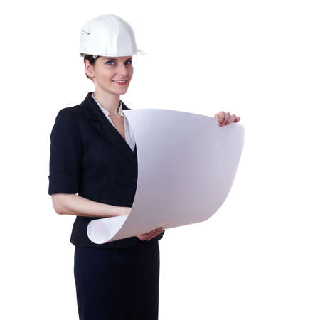 Smiling businesswoman standing over white isolated background in white helmet with blueprint, business, education, construction and architecture conceptの写真素材