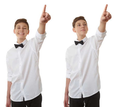 Set of cute teenager boy in white shirt and black bow tie pointing up side over white isolated background, half bodyの写真素材