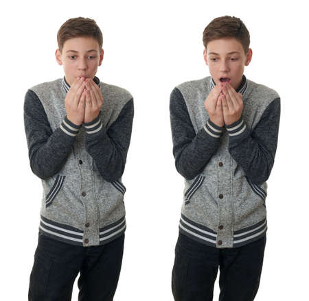 Set of cute teenager boy in gray sweater heating hands over white isolated background, half bodyの写真素材
