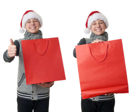 Set of cute teenager boy in gray sweater and christmas hat holding one red shopping bag over white isolated background, half bodyの写真素材