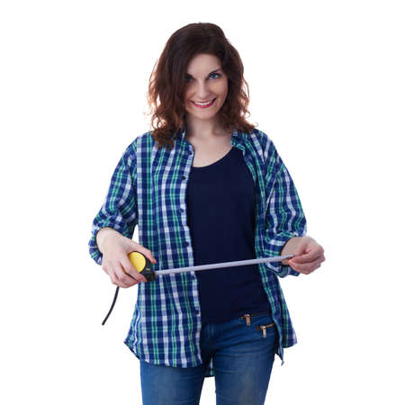 Smiling young woman in casual clothes over white isolated background holding measuring tape, happy people and construction conceptの写真素材
