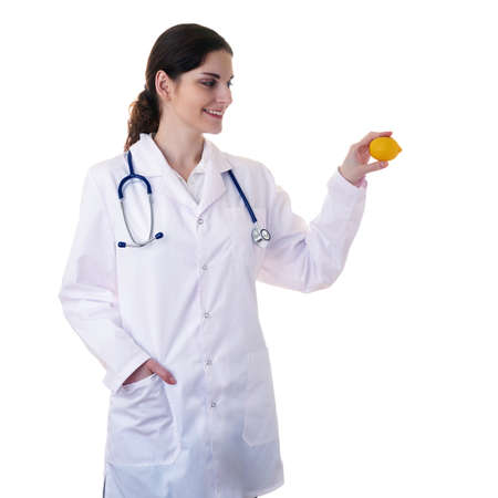 Smiling female doctor in white coat over white isolated background with stethoscope and lemon in hand, healthcare, profession and medicine conceptの写真素材