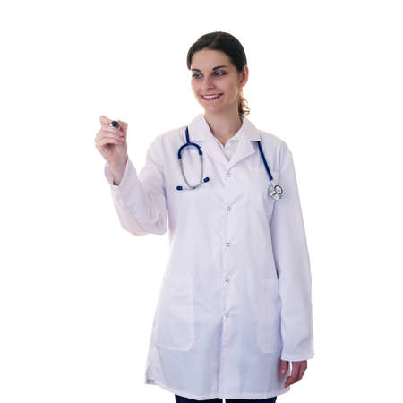 Smiling female doctor in white coat over white isolated background with stethoscope and marker in hand, healthcare, profession and medicine conceptの写真素材