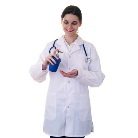 Smiling female doctor in white coat over white isolated background with stethoscope and liquid soap, healthcare, profession and medicine conceptの写真素材
