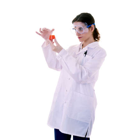 Female assistant scientist in white coat and plastic protective glasses over white isolated background inspecting flask filled with substance, healthcare, profession, science and conceptの写真素材