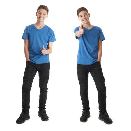 Cute teenager boy in blue T-shirt standing and poinitng forward over white isolated background full bodyの写真素材