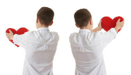 Set of cute teenager boy in white shirtholding with red plush heart from back over white isolated background, half bodyの写真素材