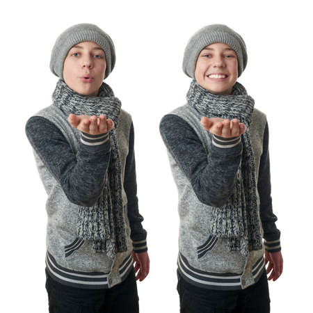 Set of cute teenager boy in gray sweater, hat and scarf blowing on hands over white isolated background, half bodyの写真素材