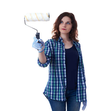 Smiling young woman in casual clothes over white isolated background paint roller, happy people and construction conceptの写真素材