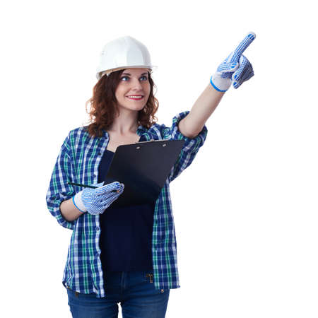 Smiling young woman in casual clothes over white isolated background in white helmet with clipboard, education, construction and architecture conceptの写真素材