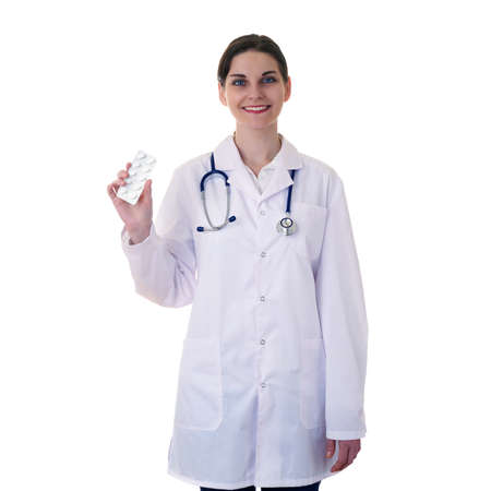 Smiling female doctor in white coat over white isolated background with stethoscope and pack of pills, healthcare, profession and medicine conceptの写真素材