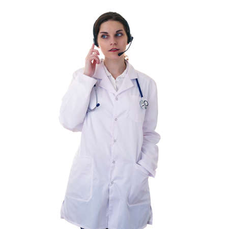Female doctor in white coat over white isolated background with stethoscope and headphones with microphone, healthcare, profession and medicine conceptの写真素材