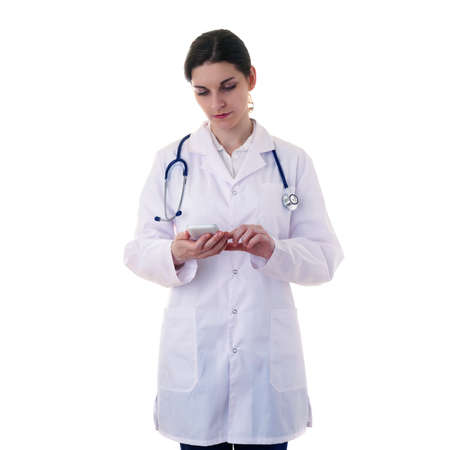 Female doctor in white coat over white isolated background with stethoscope and smart phone tablet, healthcare, profession and medicine conceptの写真素材