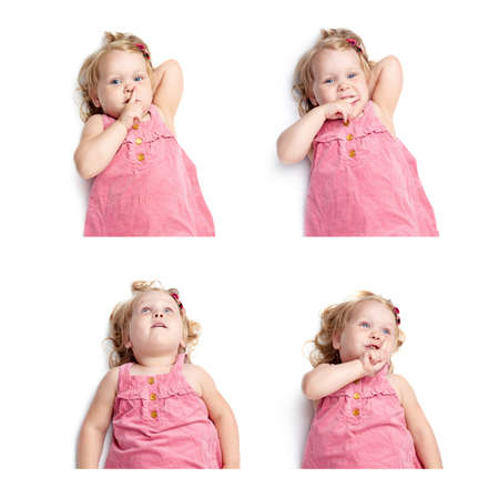 Young little girl with curly hair in pink dress lying and doing shh silence sign over isolated white backgroundの写真素材