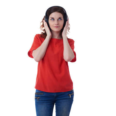 Smiling young woman in casual clothes over white isolated background with headphones, happy people, music, technology, resting conceptの写真素材