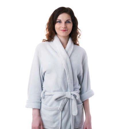 Smiling young woman in bath robe over white isolated background morning, healthy, relaxation and beauty conceptの写真素材