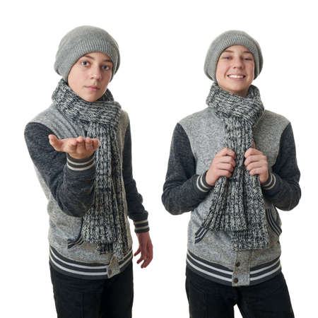 Set of cute teenager boy in gray sweater, hat and scarf holding something over white isolated background, half bodyの写真素材