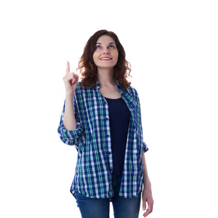 Smiling young woman in casual clothes over white isolated background pointing up, happy people conceptの写真素材