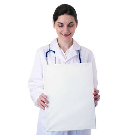 Smiling female doctor in white coat over white isolated background with stethoscope and white blank board, healthcare, profession and medicine conceptの写真素材