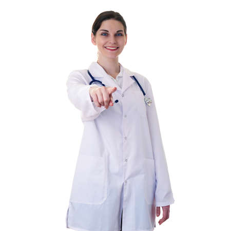 Smiling female doctor assistant in white coat over white isolated background with stethoscope and pointing, showing direction or pushing button, healthcare, profession and medicine conceptの写真素材
