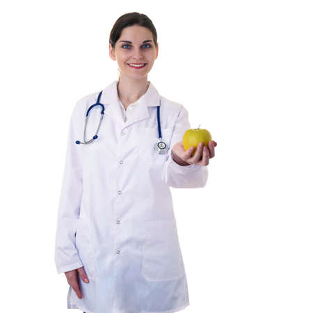 Smiling female doctor in white coat over white isolated background with stethoscope and apple in hand, healthcare, profession and medicine conceptの写真素材