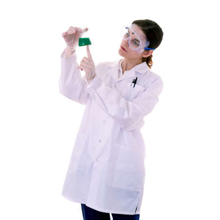 Female assistant scientist in white coat and plastic protective glasses over white isolated background inspecting flask filled with substance, healthcare, profession, science and conceptの写真素材