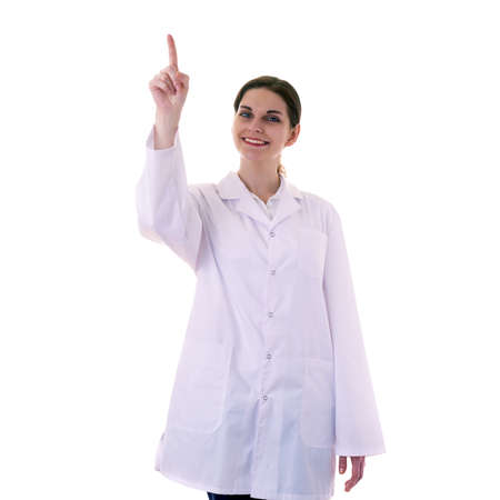 Smiling female doctor assistant scientist in white coat over white isolated background pointing, showing direction or pushing button, healthcare, profession, science and medicine conceptの写真素材