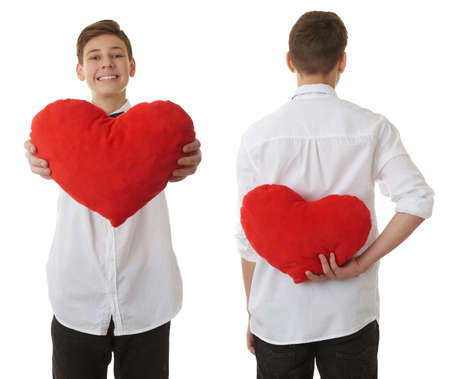 Set of cute teenager boy in white shirtholding with red plush heart over white isolated background, half bodyの写真素材