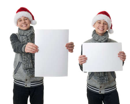 Set of cute teenager boy in gray sweater and christmas hat holding paper over white isolated background, half bodyの写真素材