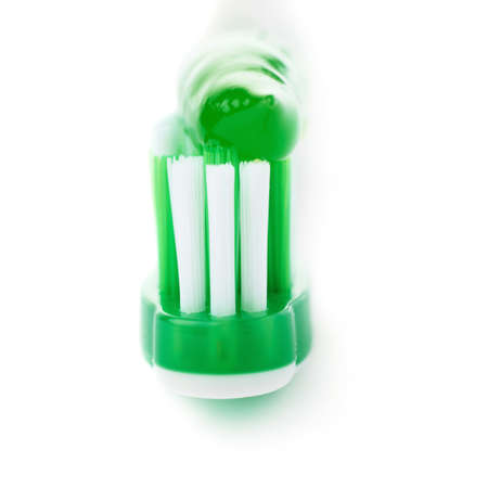 Green single toothbrush with paste isolated over white backgroundの写真素材
